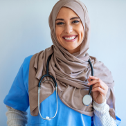 A nurse wearing a hijab, a stethoscope. and a smile. 