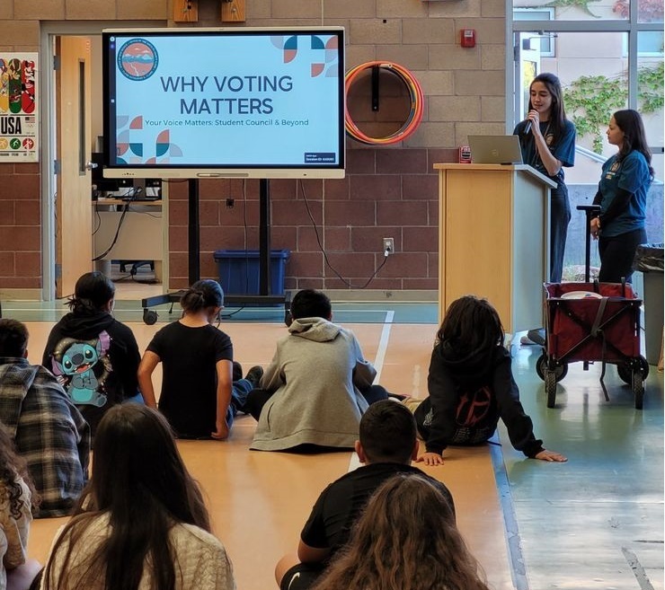 2 Clerk Staff members giving a presentation to elementary students