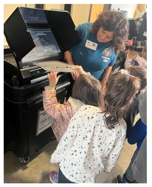 Group of THRIVE students at the tabulator, watching their friend cast a ballot