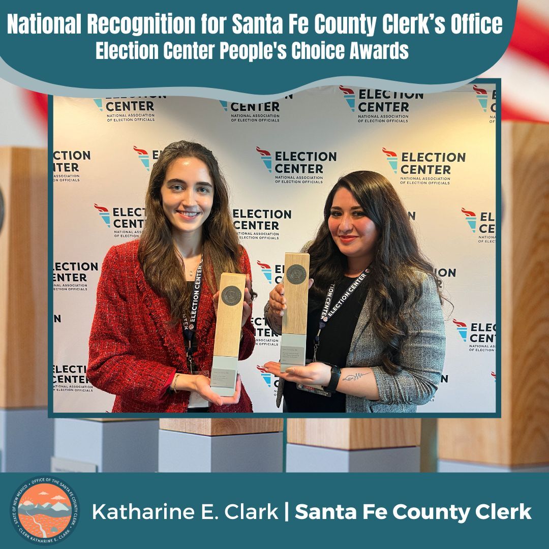 Two staff members, each holding an award