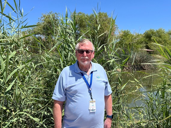 wetlands park volunteer posing in front of vern's pond