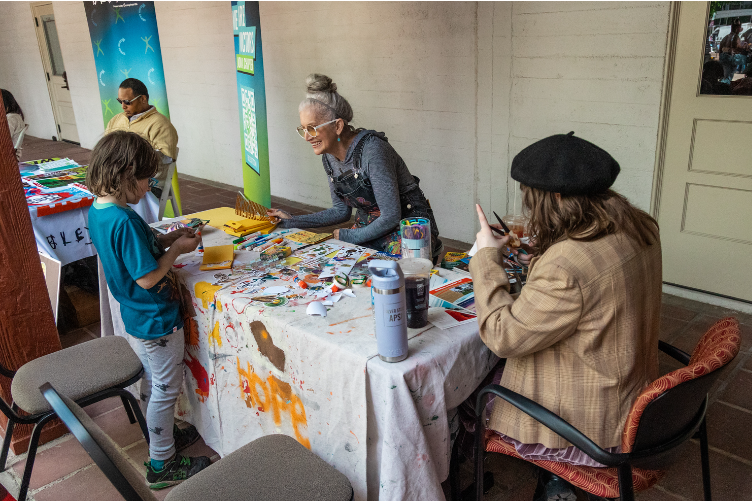 photo of two women creating art at a vendor table