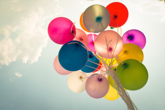 balloons against a blue sky with clouds