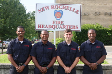 New firefighters in front of Fire Headquarters sign