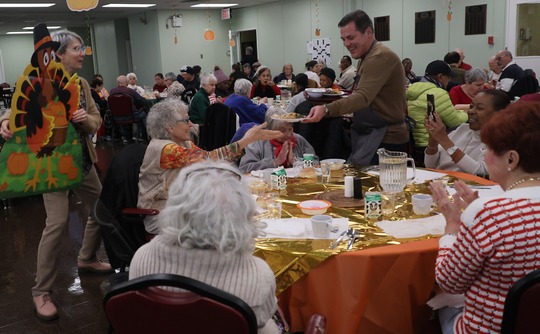 Commissioner serving holiday lunch at a table