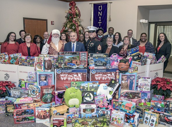 Comptroller and staff with toys collected for drive.