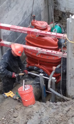 Installing a large red valve on the Samon River Reservoir Pipeline