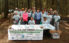 A group of volunteers posing for a picture around a picnic table.