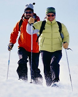 a couple snowshoeing on a sunny day