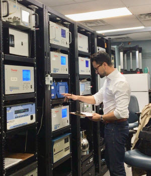 Santosh Mahat performing a weekly check of the ground-level ozone analyzer