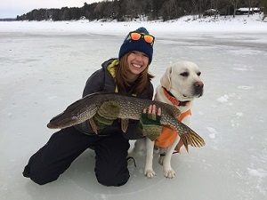 Young woman with large fish and dog