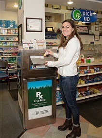 Woman depositing medication into disposal box