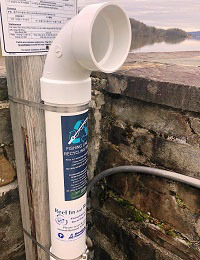 A plastic tube fixed to a wall by the Hudson River is used for collecting fishing line.
