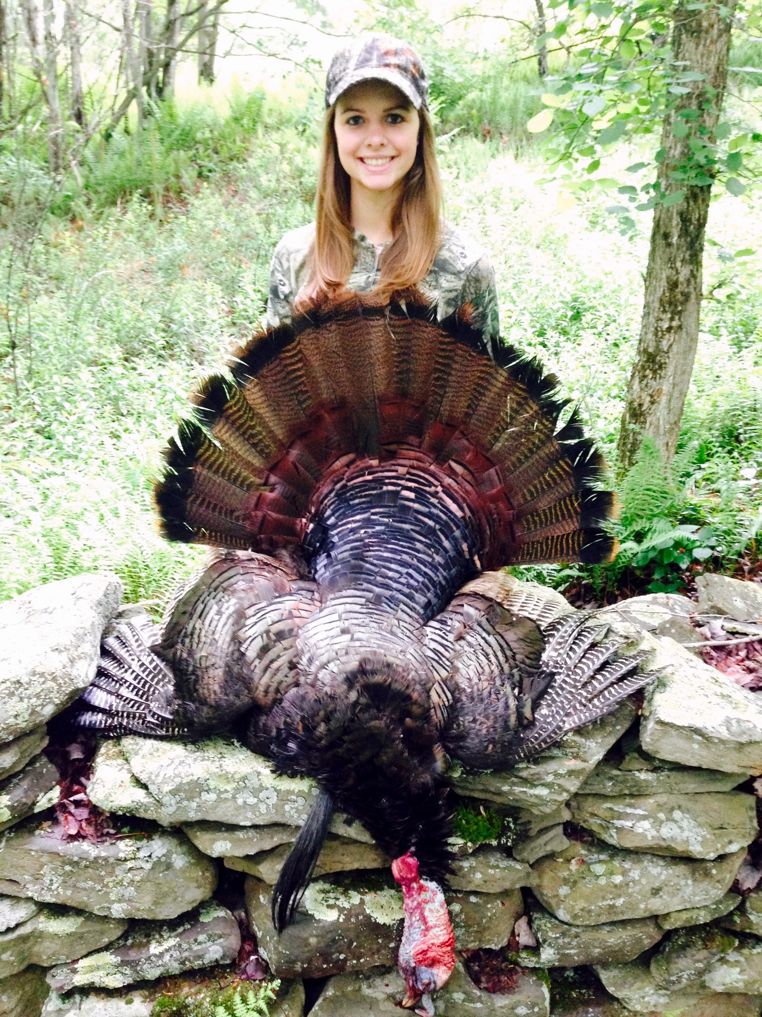A young woman displaying the turkey she took.