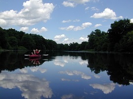A woman in a kayak rests on the peaceful Walkill River.