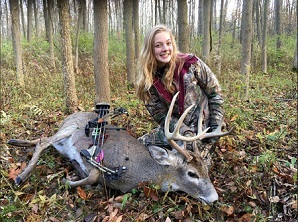 Girl posing with deer she took with a bow