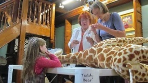 Girl fixing stuffed giraffe