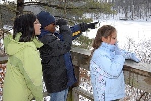 3 youth with binoculars looking for birds