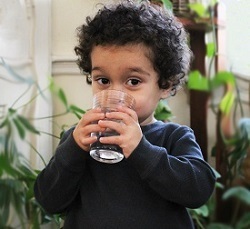 Young boy drinking a glass of water