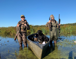 youth hunters with dog in canoe