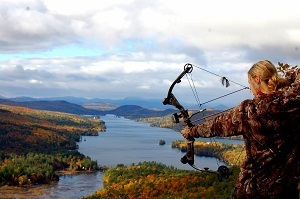 Woman aiming a compound bow in the Adirondacks