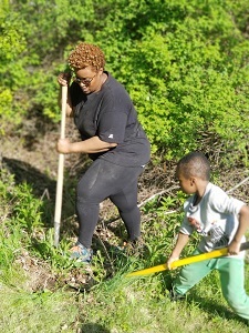 A woman and a child digging a hole to plant a tree