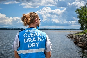 a man in a boat steward vest gazes out at a lake