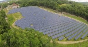 Aerial view of a solar farm-- a large field filled with solar panels, located in Beacon, NY.