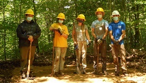 five SCA crew members wearing hart hats and masks, standing in a row