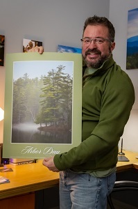 Dave Marshall holds the 2021 Arbor Day poster containing his photograph