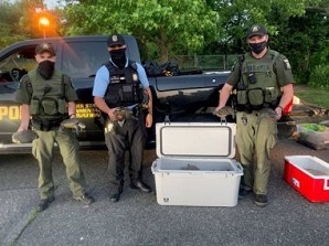 Three ECOs pose with cooler containing illegally seized turtles