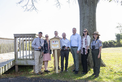 Commissioner Basil Seggos and several partners standing at the new NYSBT sign overlooking a wildlife viewing platform