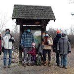 A group of hikers standing at a pond at a First Day Hike