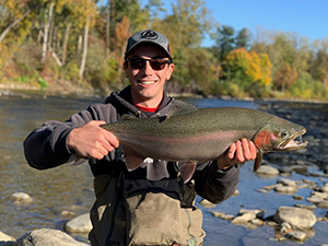 Angler holding up Rainbow Trout