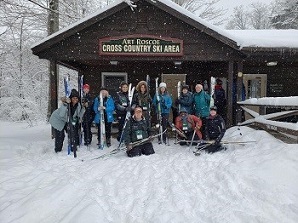 BOW in the Snow participants pose with cross-country skis in front of a lodge