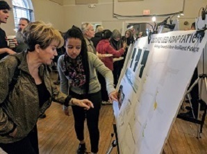 Two women looking at information on a posterboard