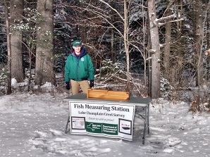 DEC staff standing next to fish measuring station 