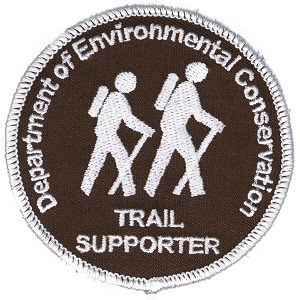 the current patch design features two hikers in white embroidery on a brown background