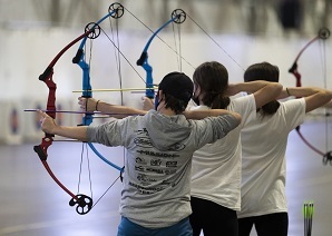 Students participating in the tournament draw their bows in preparation to shoot