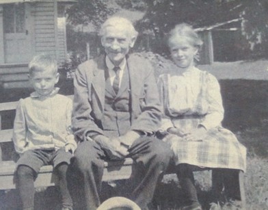 A man sitting on a bench with two small children