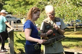 a woman being instructed about fishing