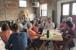 A group of people around a table discuss resilience.