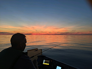Angler fishing on Lake Erie during sunset