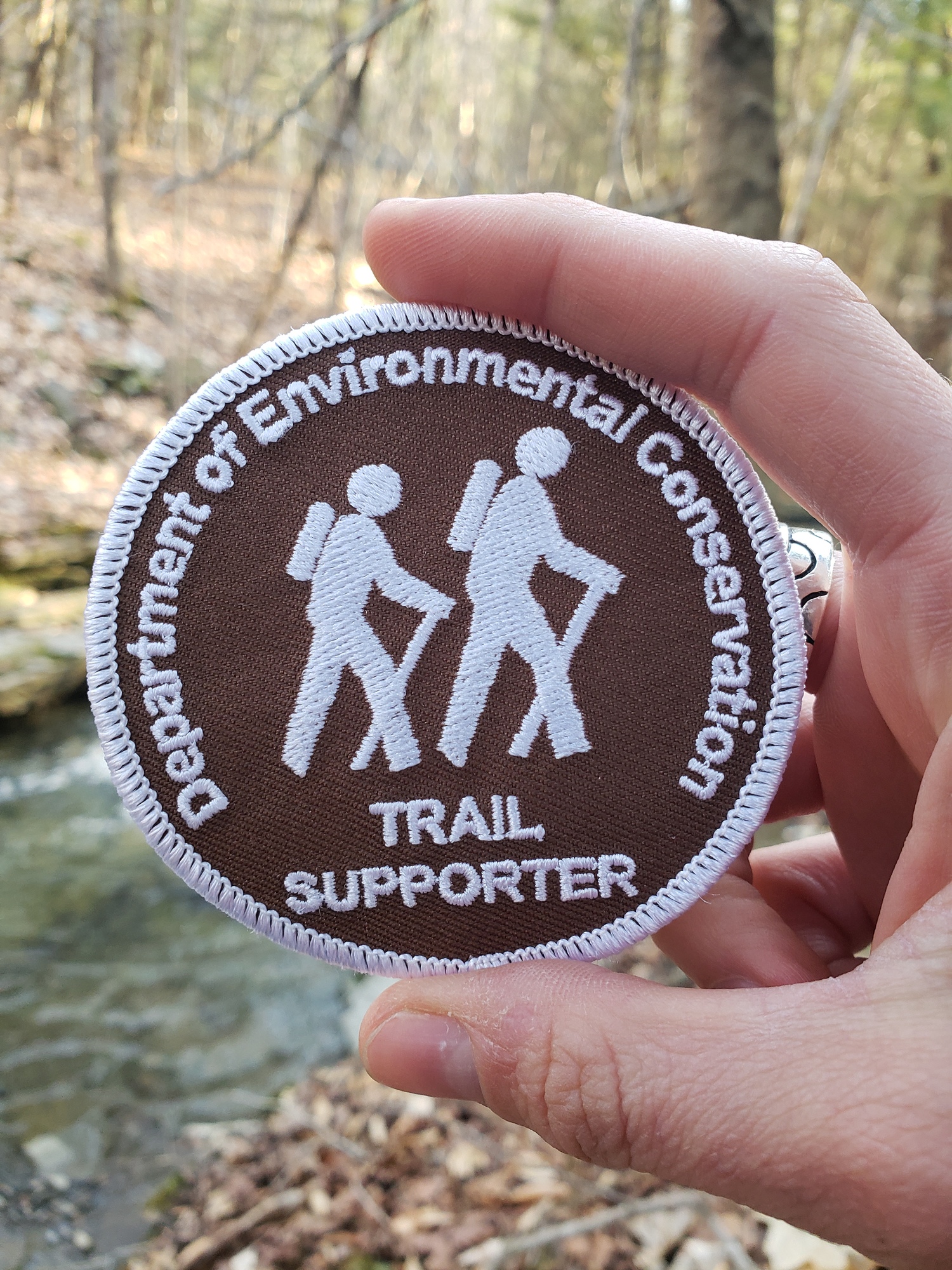 Hiking patch with hikers on brown background