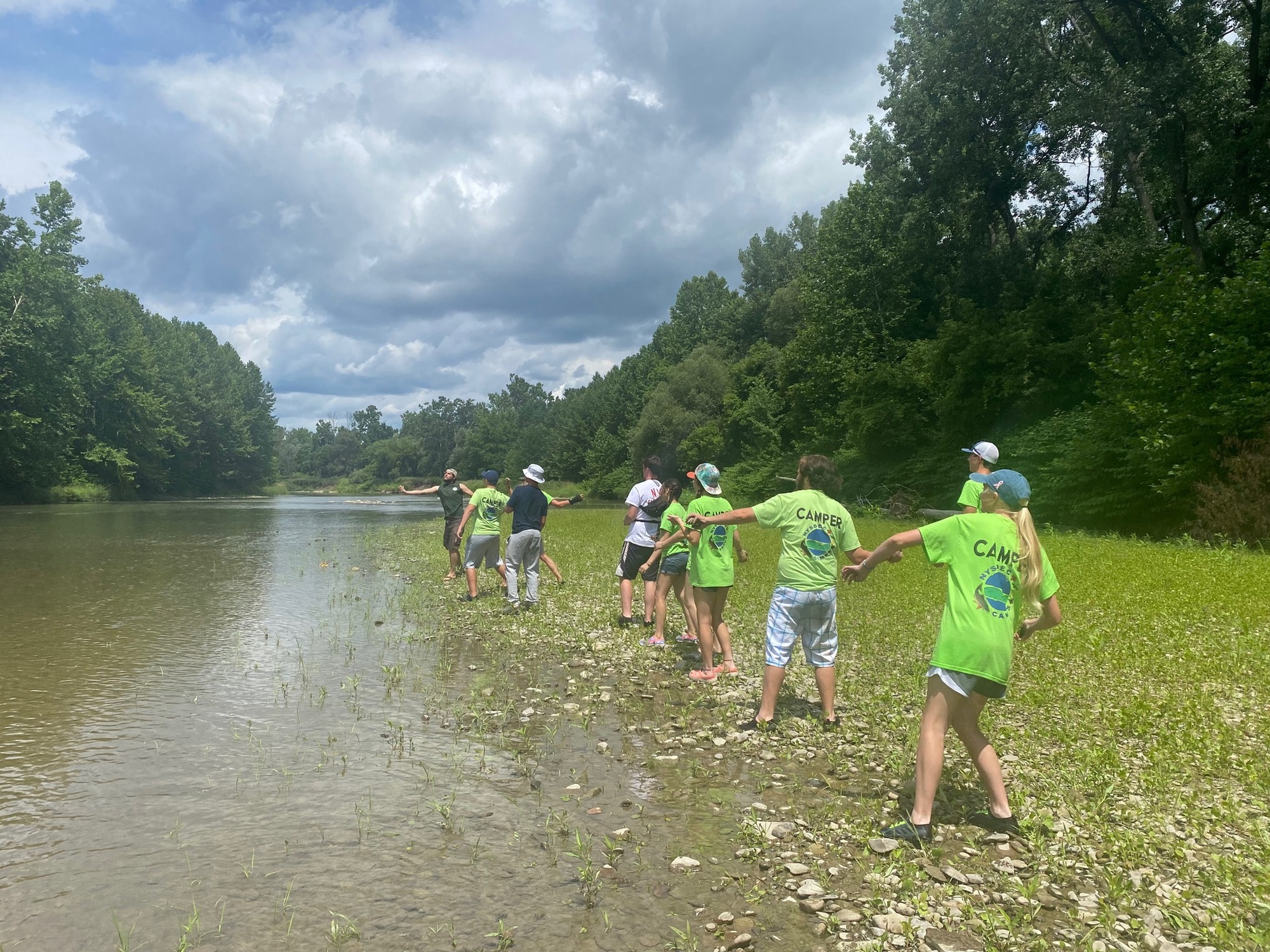 A group of summer camp attendees learning to fly fish