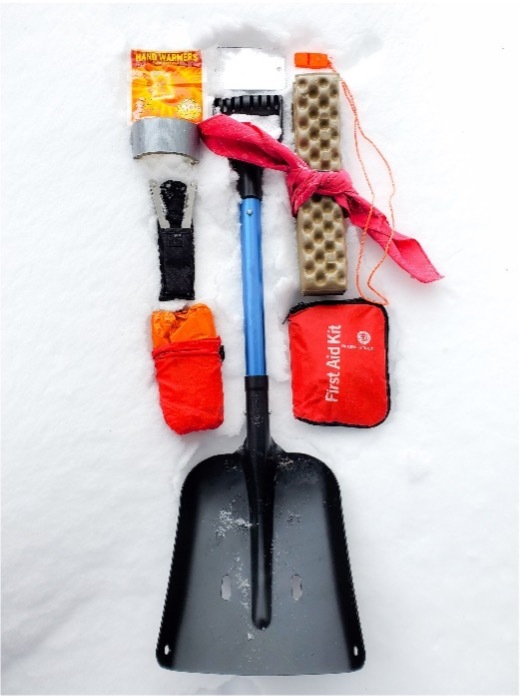 Emergency kit contents laid out on snow