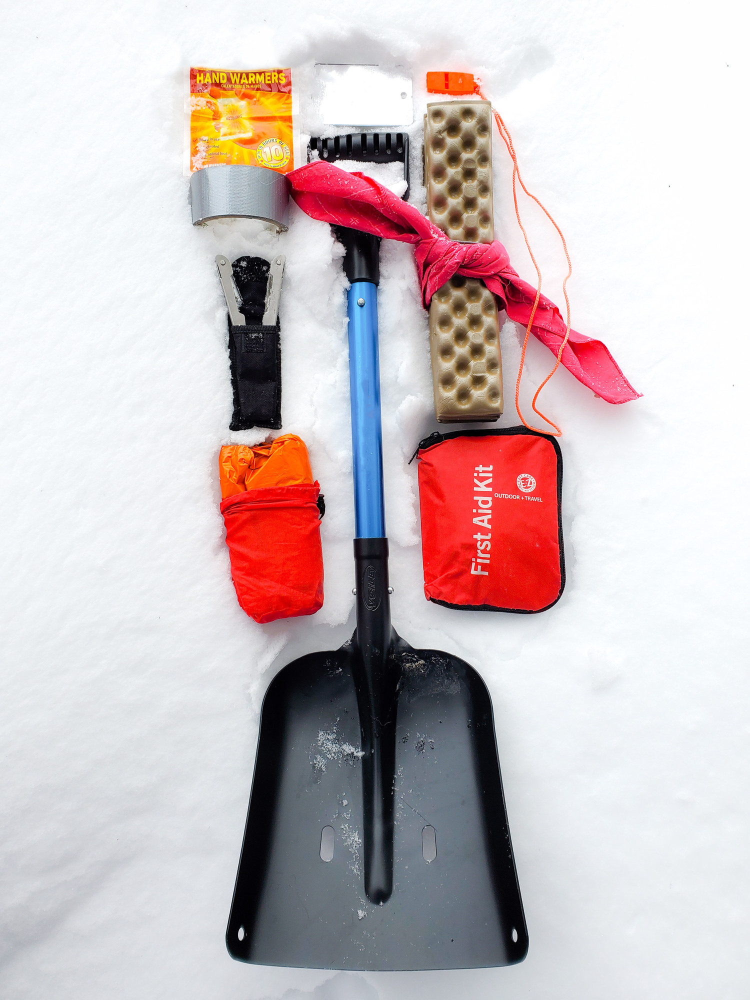 Winter Emergency Kit laid out on snow