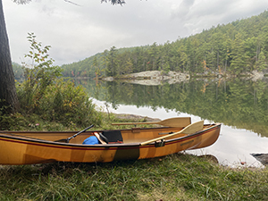 Canoe sitting on the lake shore.