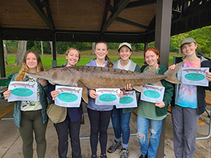Lyncourt School students holding a model lake sturgeon with their certificates.