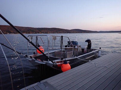 DEC electrofishing boat docked on a lake at sunset.